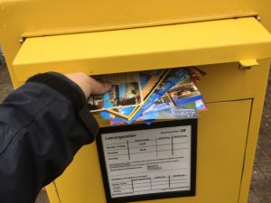 Foto: Postkarten in den Briefkasten werfen